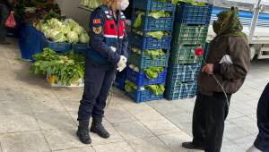 Jandarma pazar'da  yaşlıları  karanfil vererek ikazda bulunuyor.
